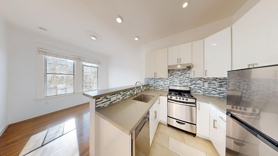 A modern kitchen with a stove top oven and a sink.