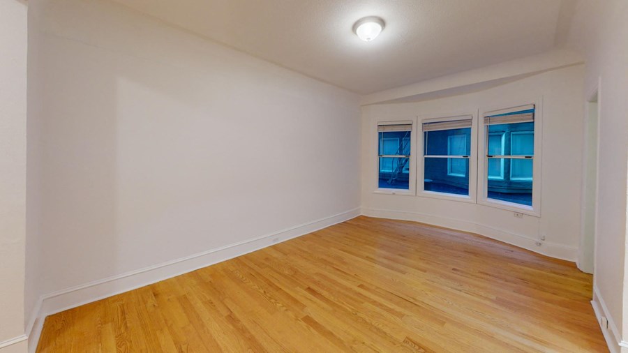 a living room with white walls and wood floors