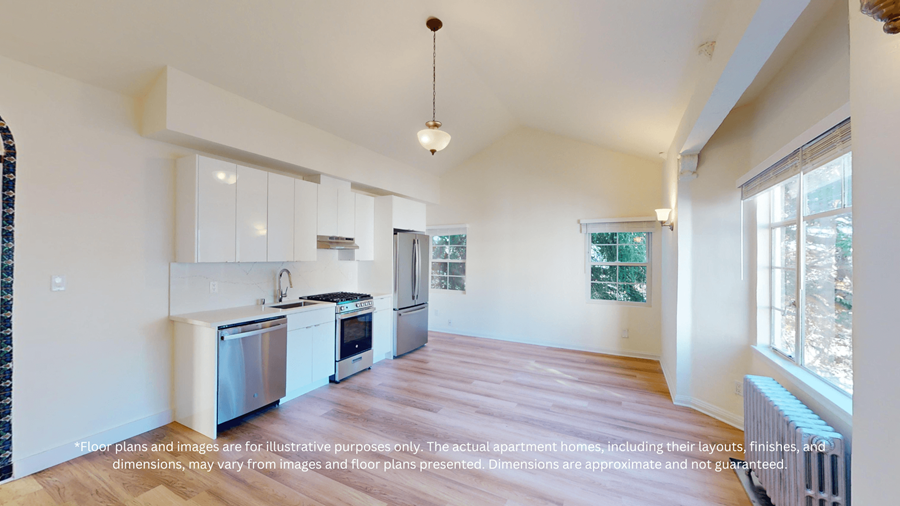 A kitchen with white cabinets and a wooden floor.