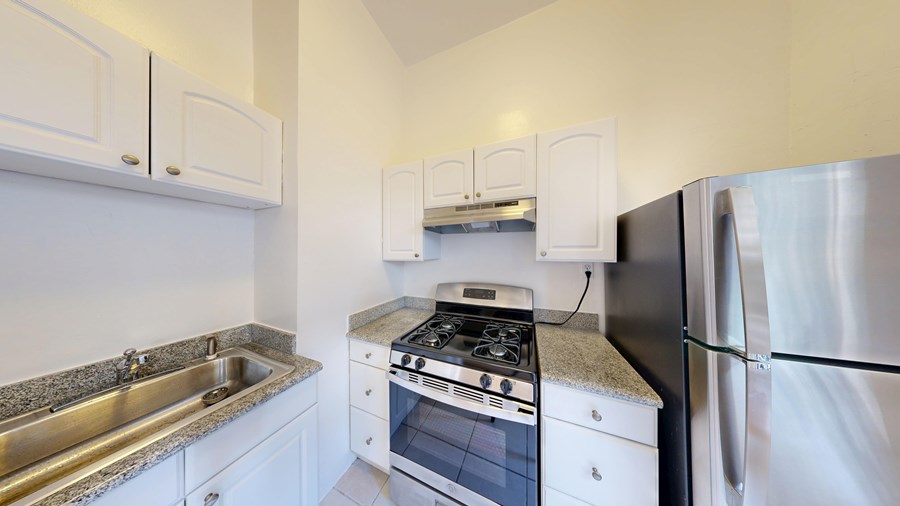 A kitchen with white cabinets and stainless steel appliances.