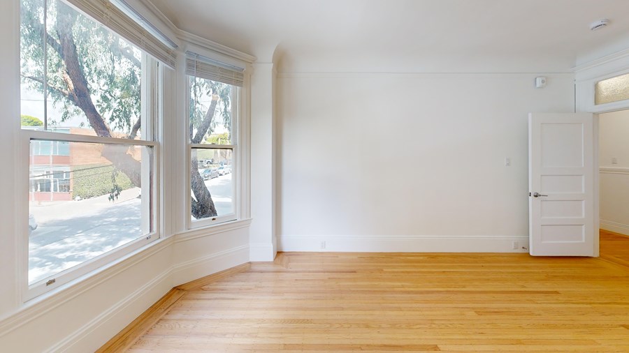 A room with wooden floors and a white door.