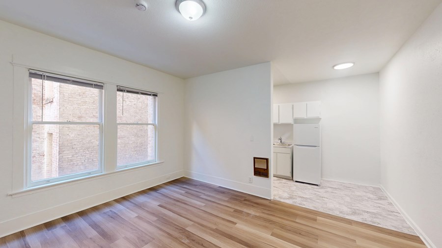 A room with a white wall and a wooden floor.