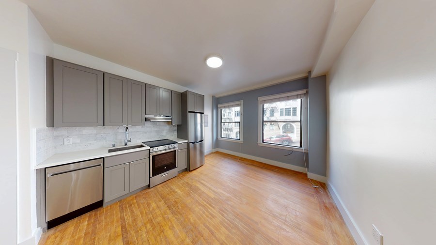 A kitchen with wooden floors and stainless steel appliances.