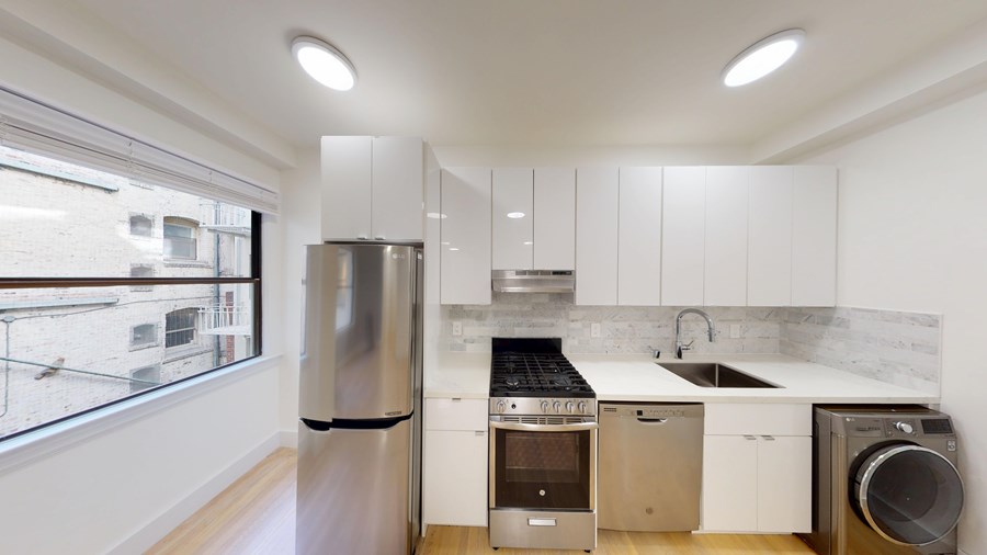 A modern kitchen with stainless steel appliances and white cabinetry.