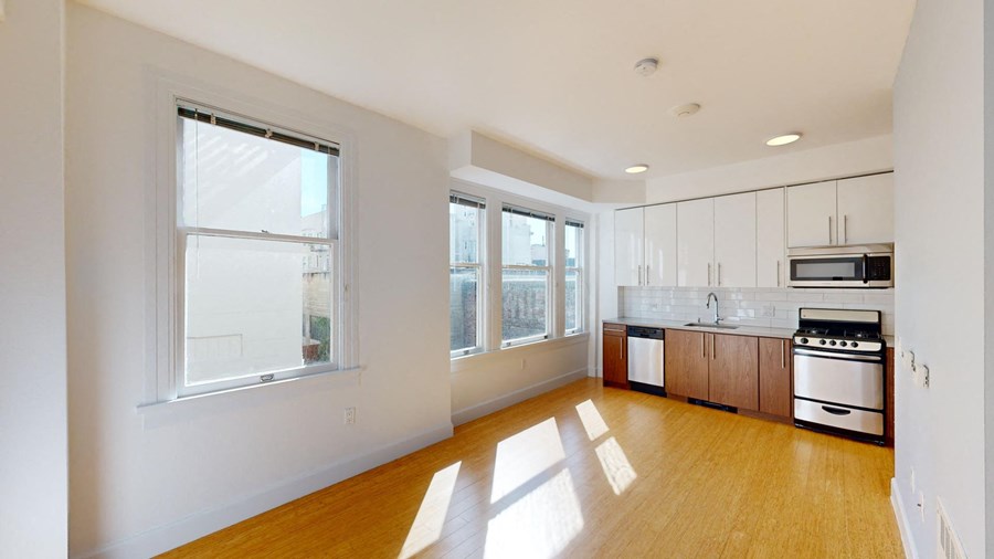 a kitchen with a wood floor and a large window