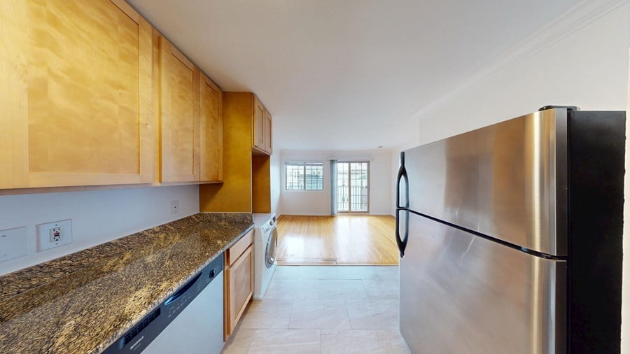 A kitchen with wooden cabinets and a granite countertop.