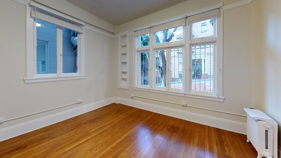 A room with a window and a radiator on the floor.