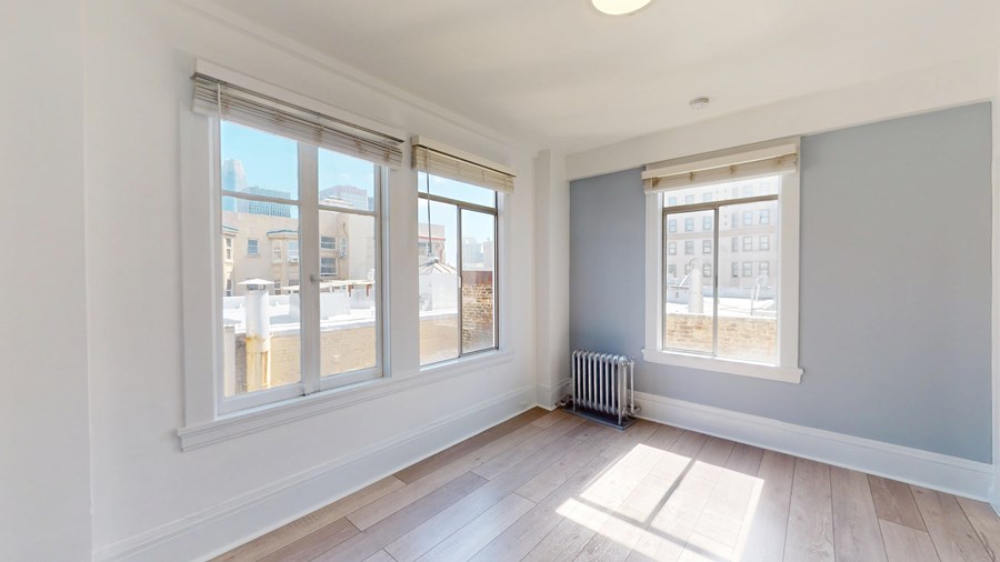 A room with a window and a radiator on the floor.