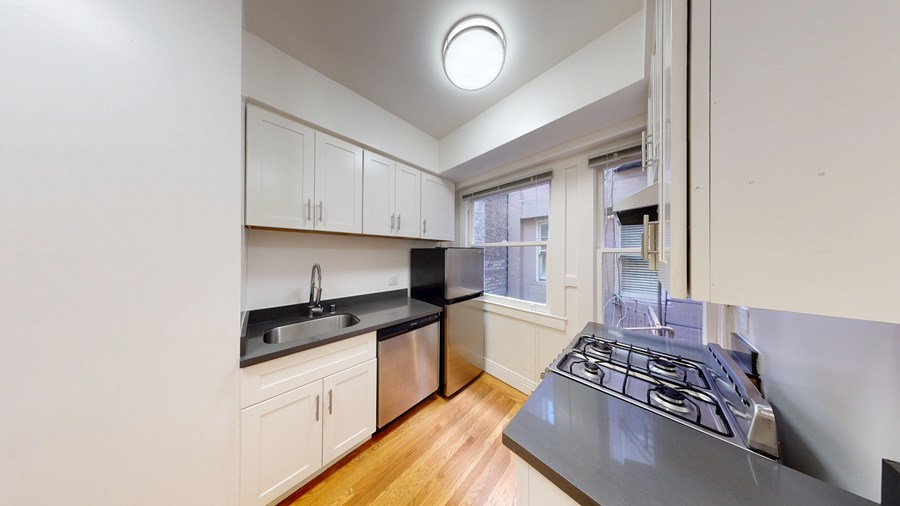 A kitchen with a stove top oven and a sink.