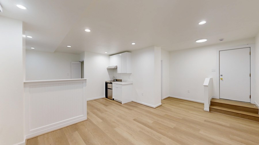 A white room with wooden floors and a white cabinet.