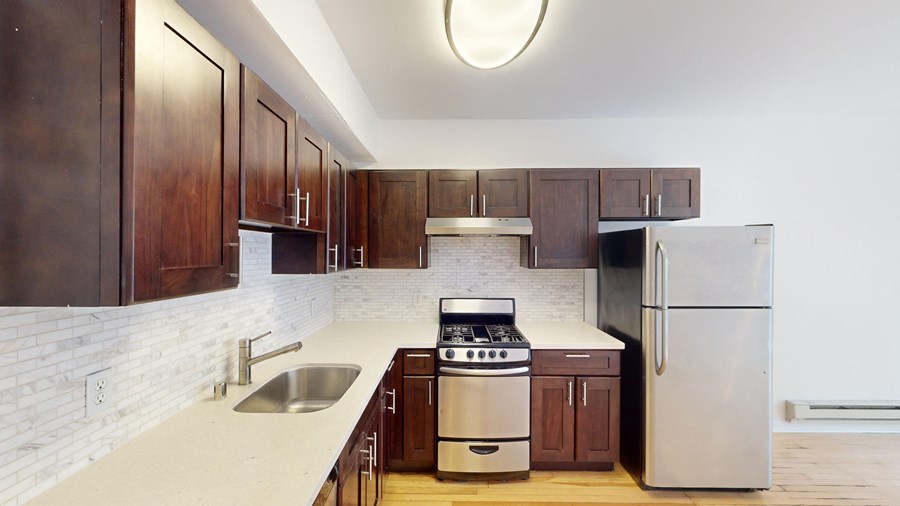 A kitchen with dark wood cabinets and stainless steel appliances.