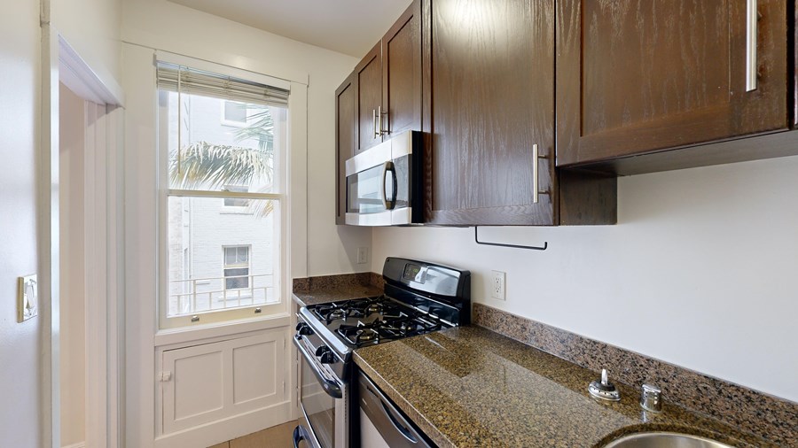 A kitchen with a stove top oven and microwave.