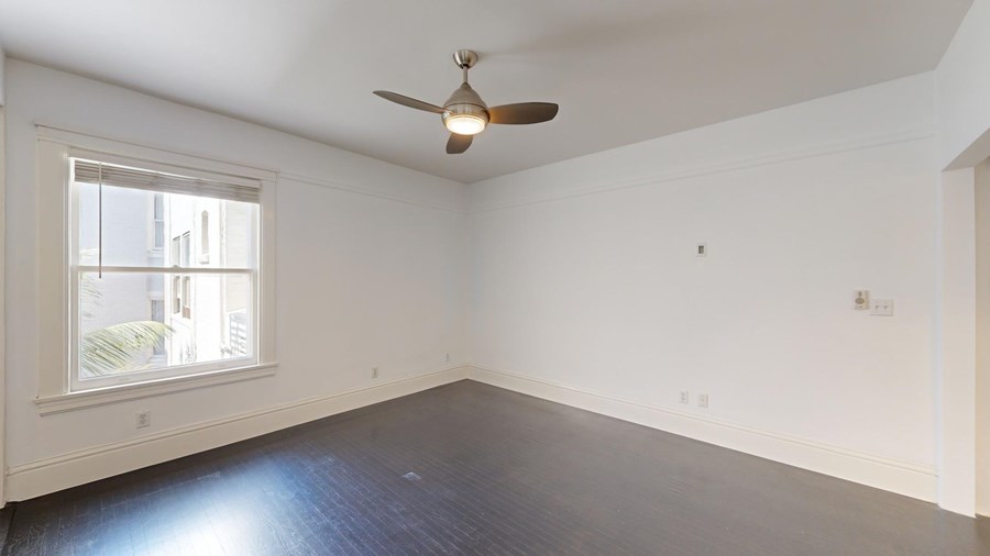 A room with a ceiling fan and a window.