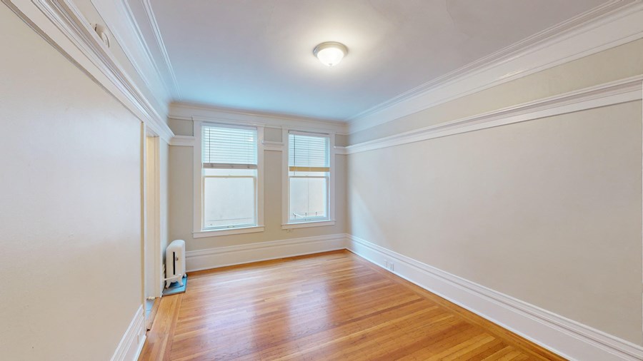 A room with a wooden floor and a window.