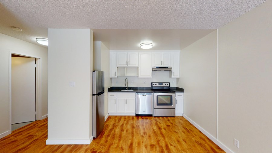 A kitchen with white cabinets and stainless steel appliances.