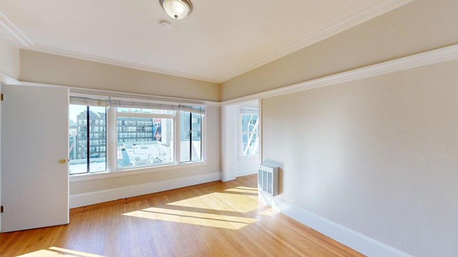 an empty living room with wood floors and windows