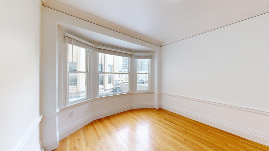 A room with a window and wooden floors.