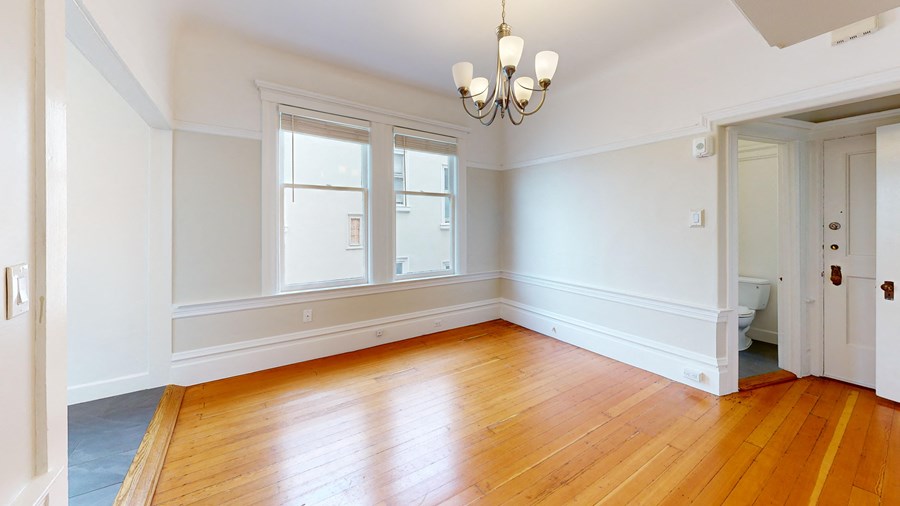 an empty living room with white walls and wood floors