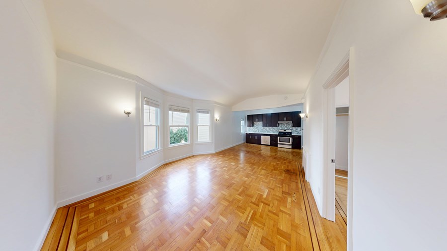 A room with wooden flooring and white walls.