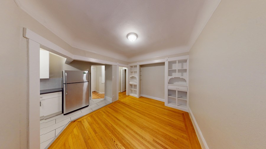 A kitchen with wooden floors and white walls.
