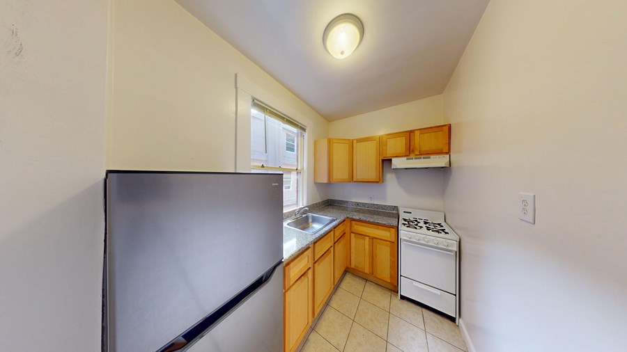A kitchen with a refrigerator, dishwasher, and stove.