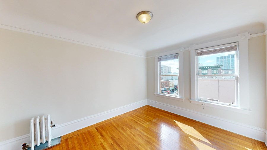 A room with a white wall and a wooden floor.