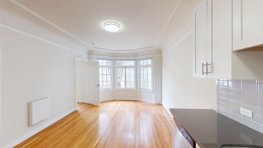 A kitchen with a wooden floor and white walls.