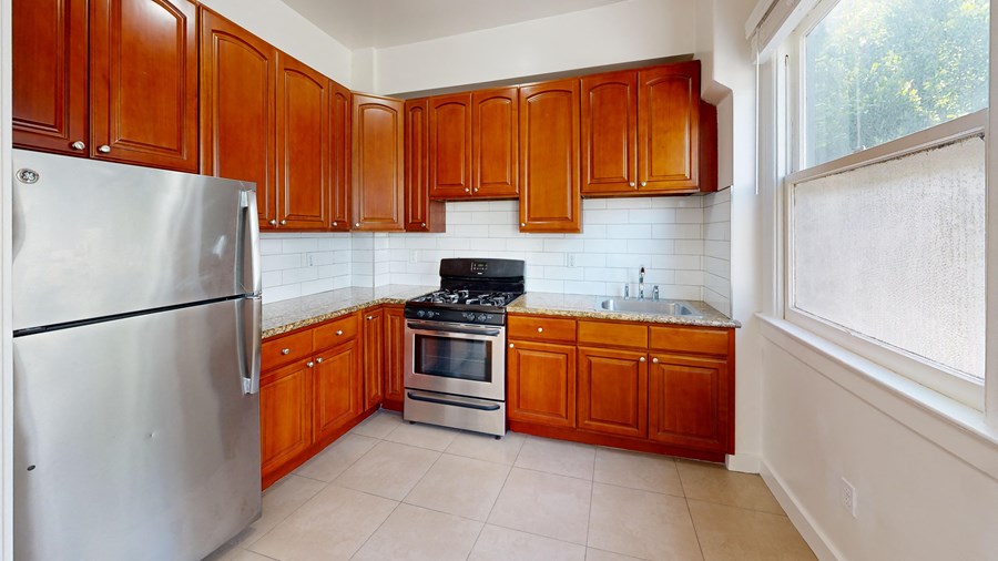 a kitchen with wooden cabinets and stainless steel appliances