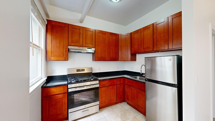 A kitchen with wooden cabinets and a black countertop.