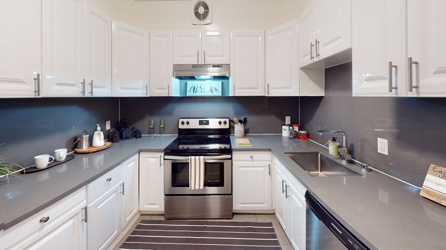 A modern kitchen with a stainless steel oven and white cabinets.