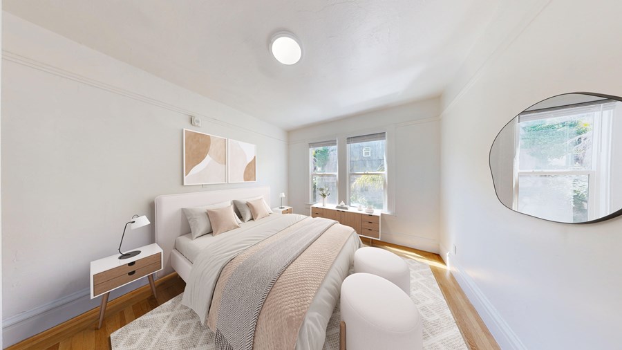 A bedroom with a large bed and a round mirror on the wall.