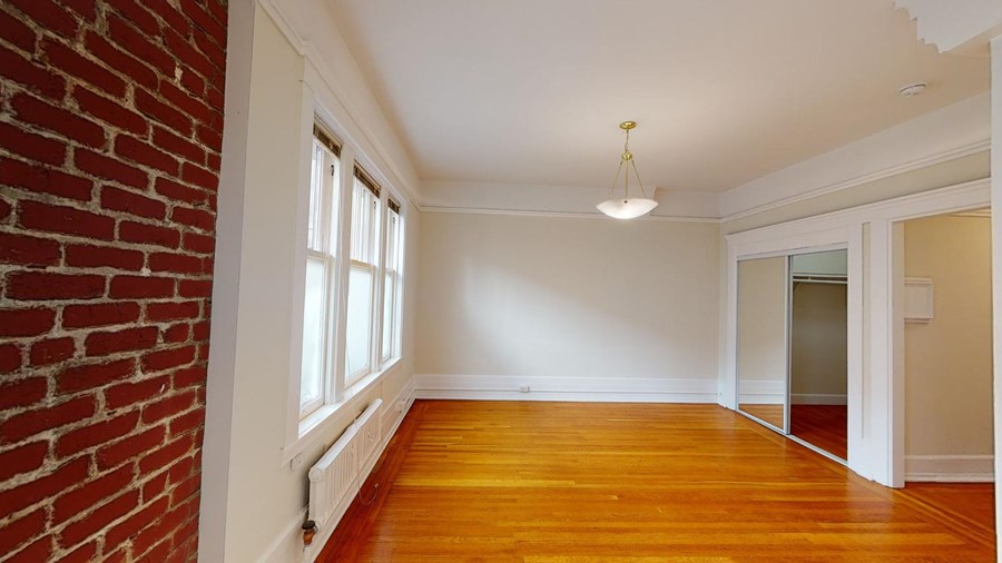 A room with a brick wall and wooden floors.