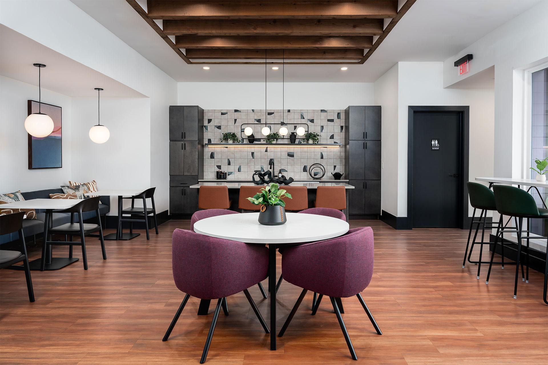 A dining room with a white table and purple chairs.