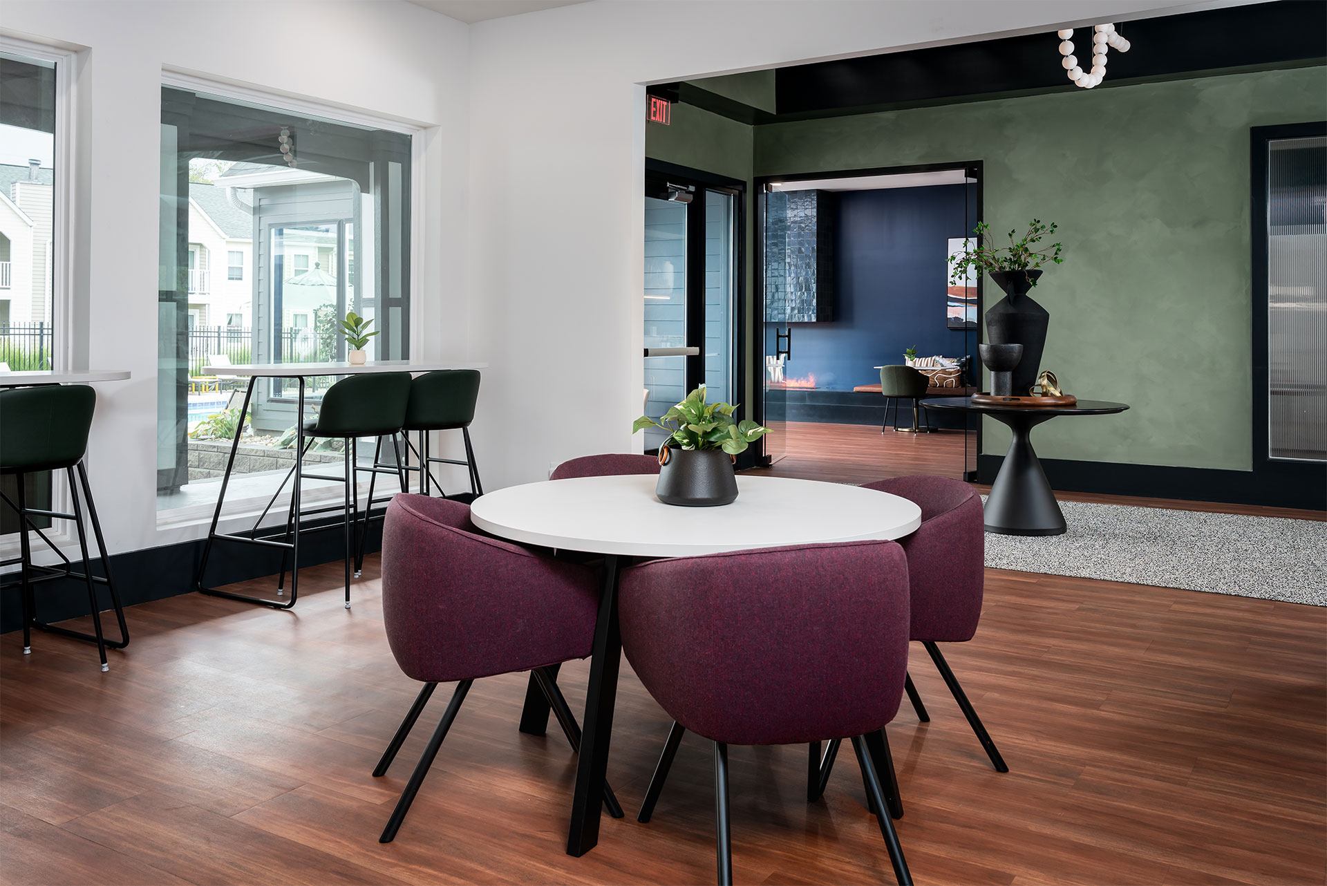 A white table with a vase on it and four chairs around it.