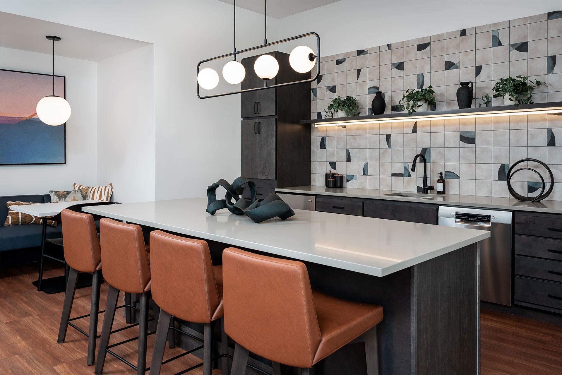 A modern kitchen with a long white island and brown bar stools.