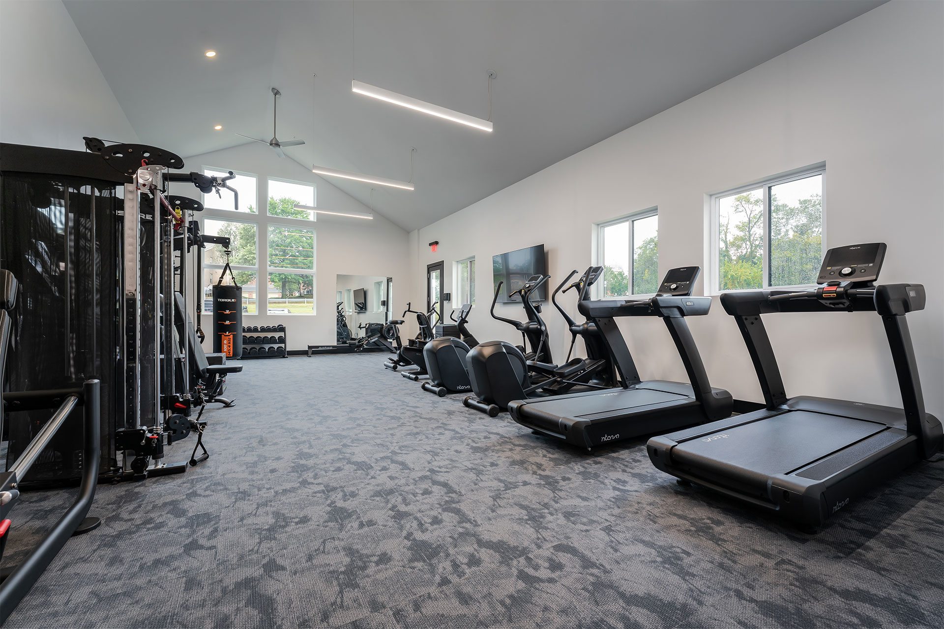 A gym with treadmills, elliptical machines, and other exercise equipment.