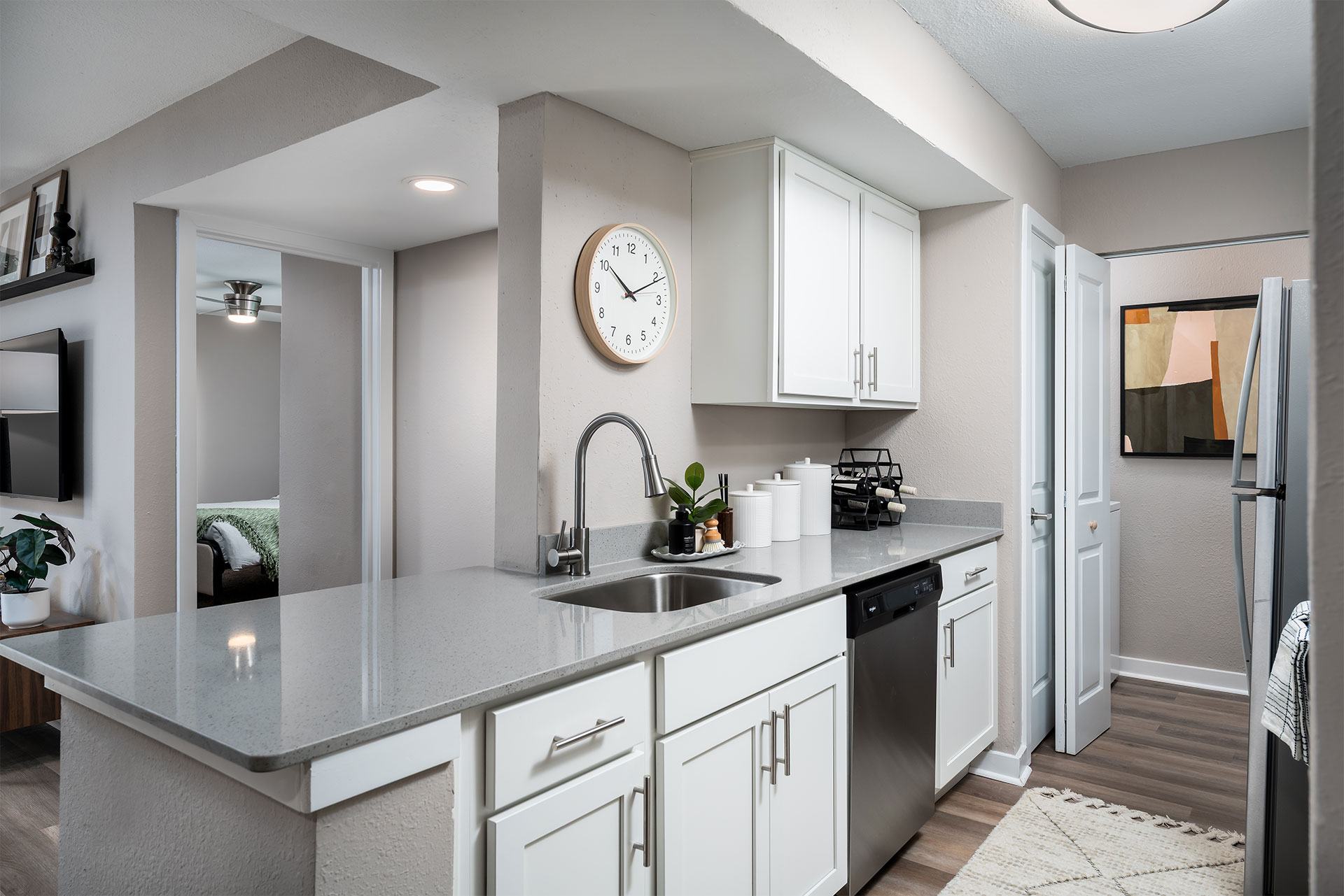 A modern kitchen with a large island and a clock on the wall.