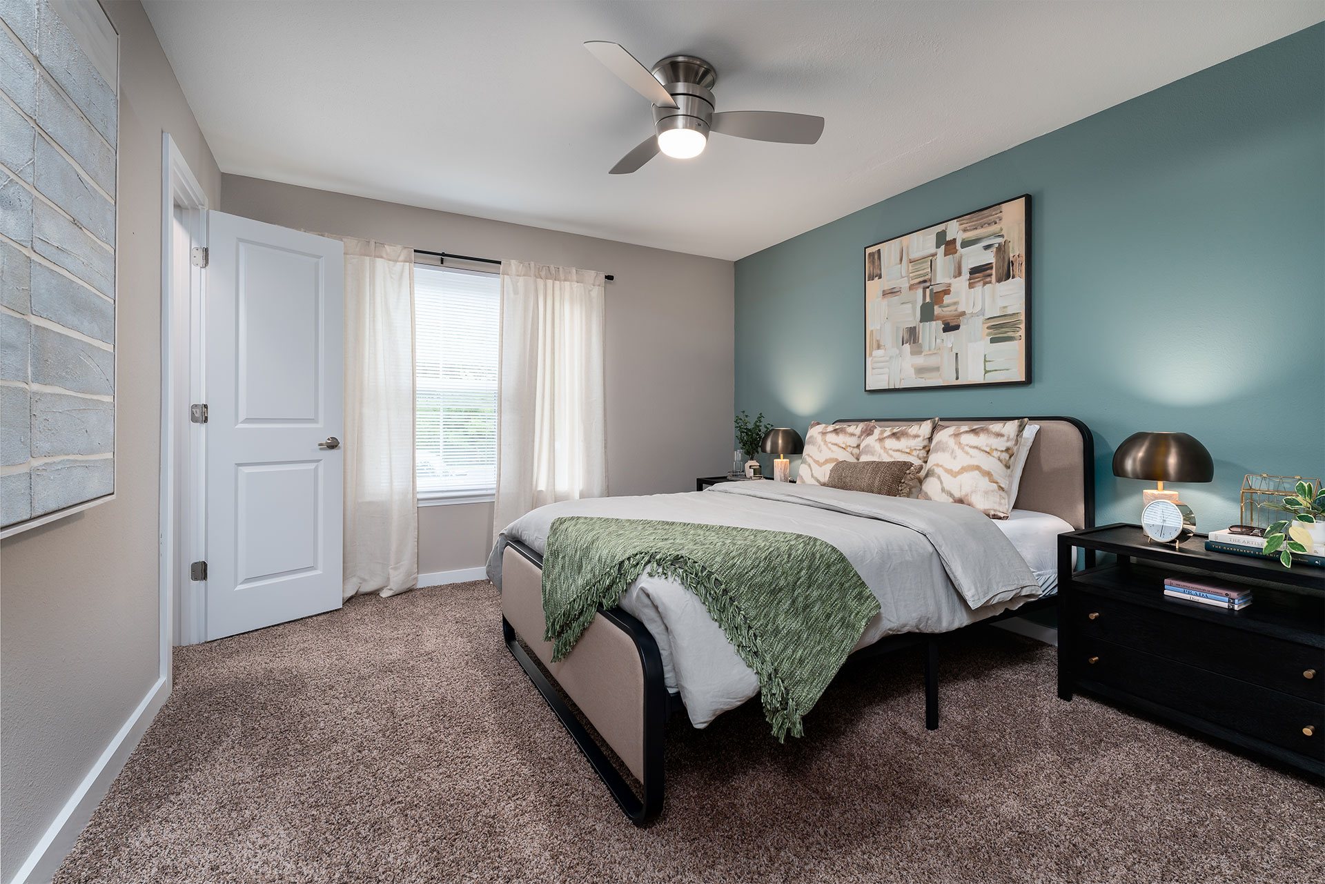 A bedroom with a bed, nightstand, and a ceiling fan.