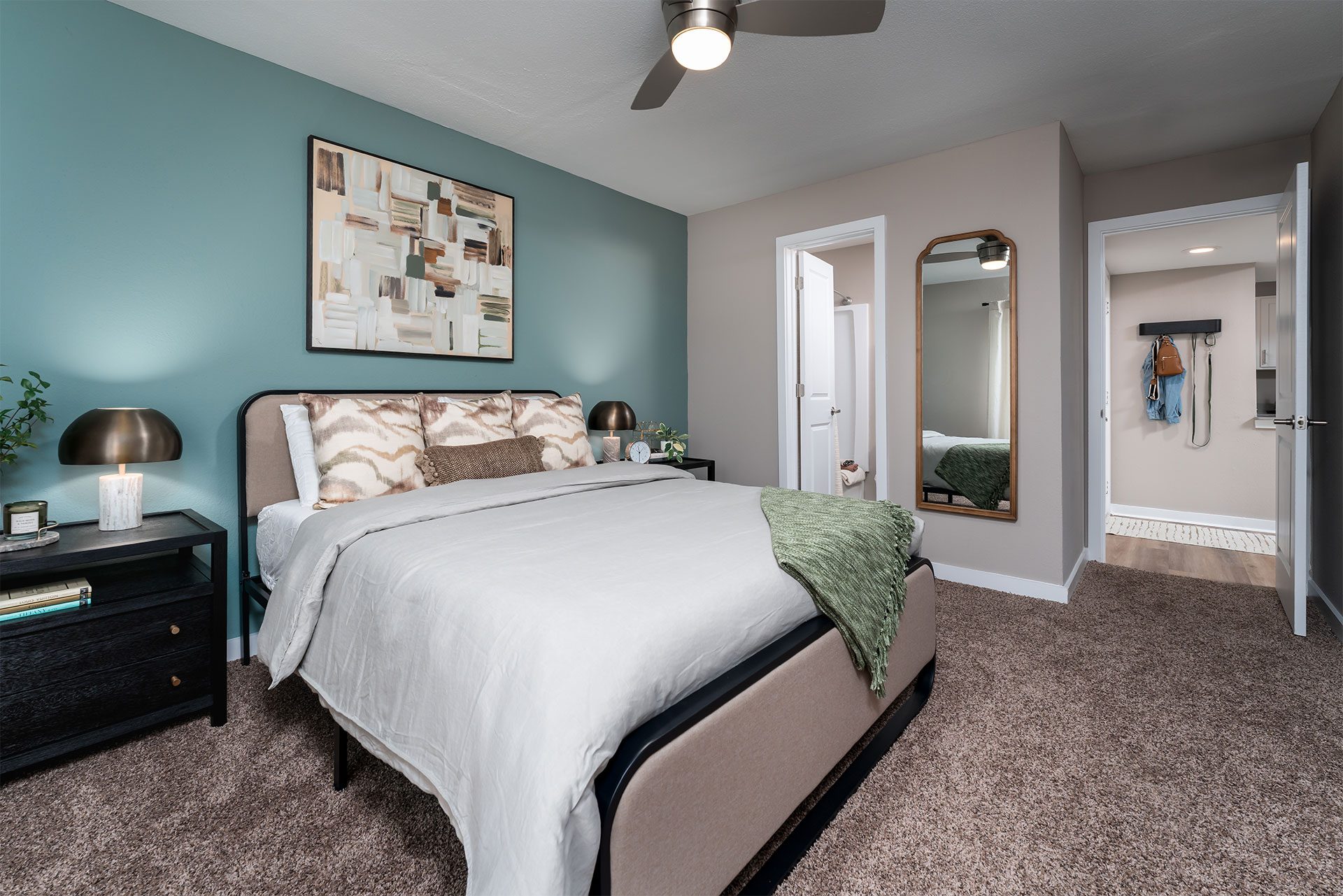 A bedroom with a bed, nightstand, and a ceiling fan.