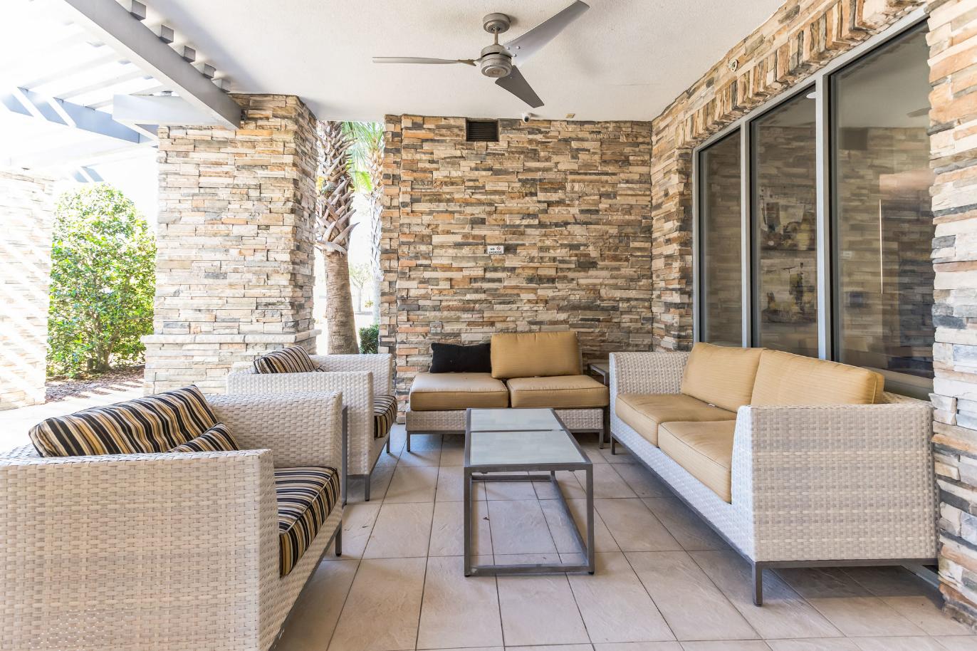 a patio with couches and a table and a brick wall