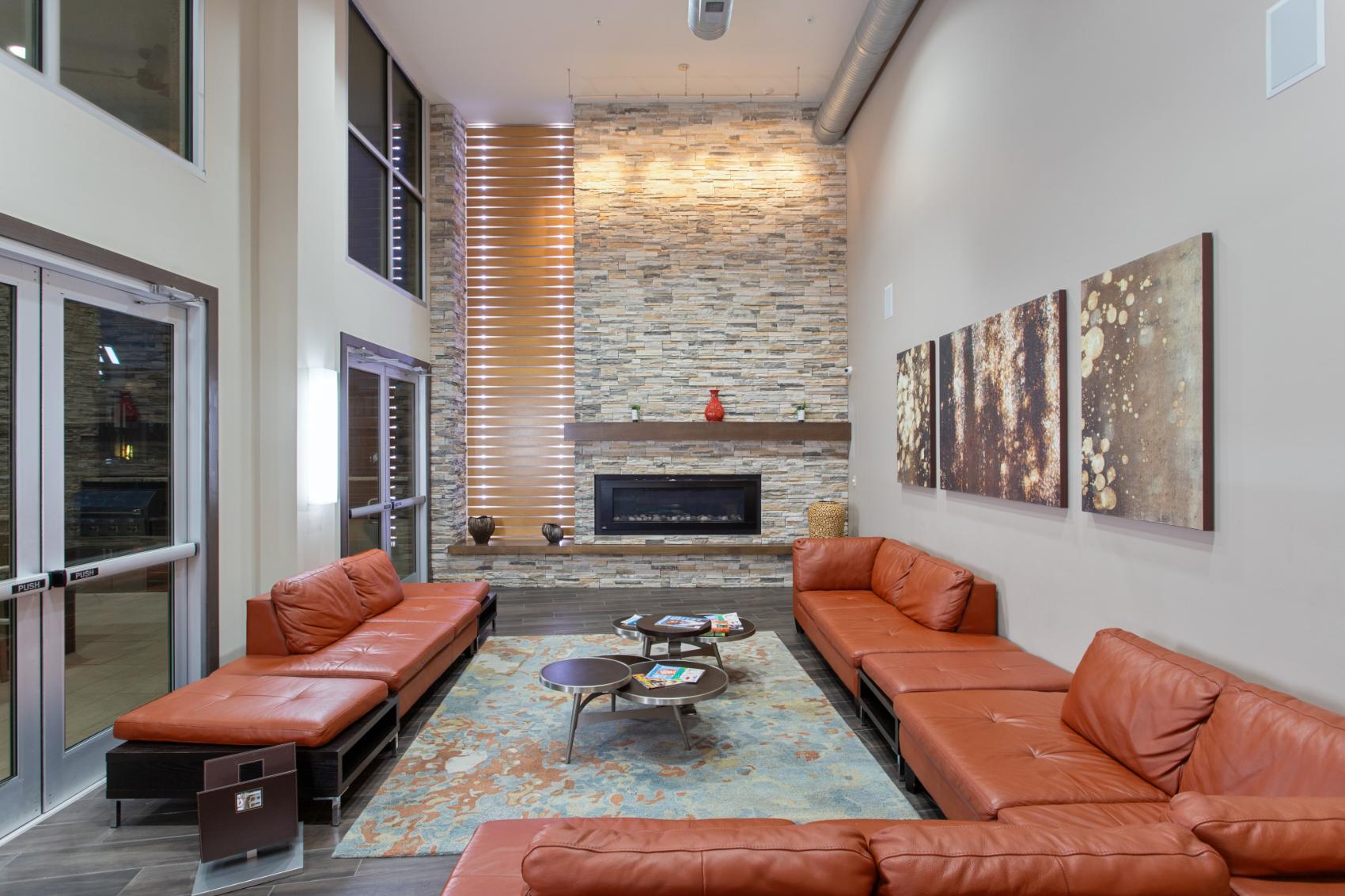a living room with leather couches and a stone fireplace