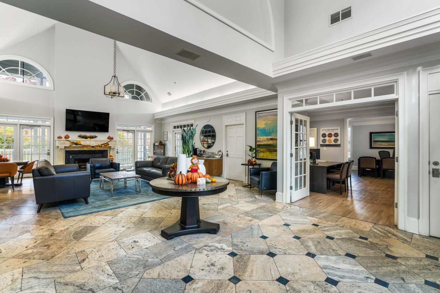 A large, open living room with a stone floor and a fireplace.