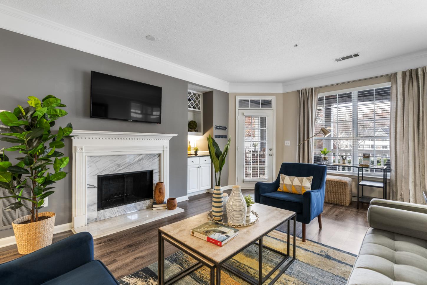 A living room with a fireplace and a television above it.