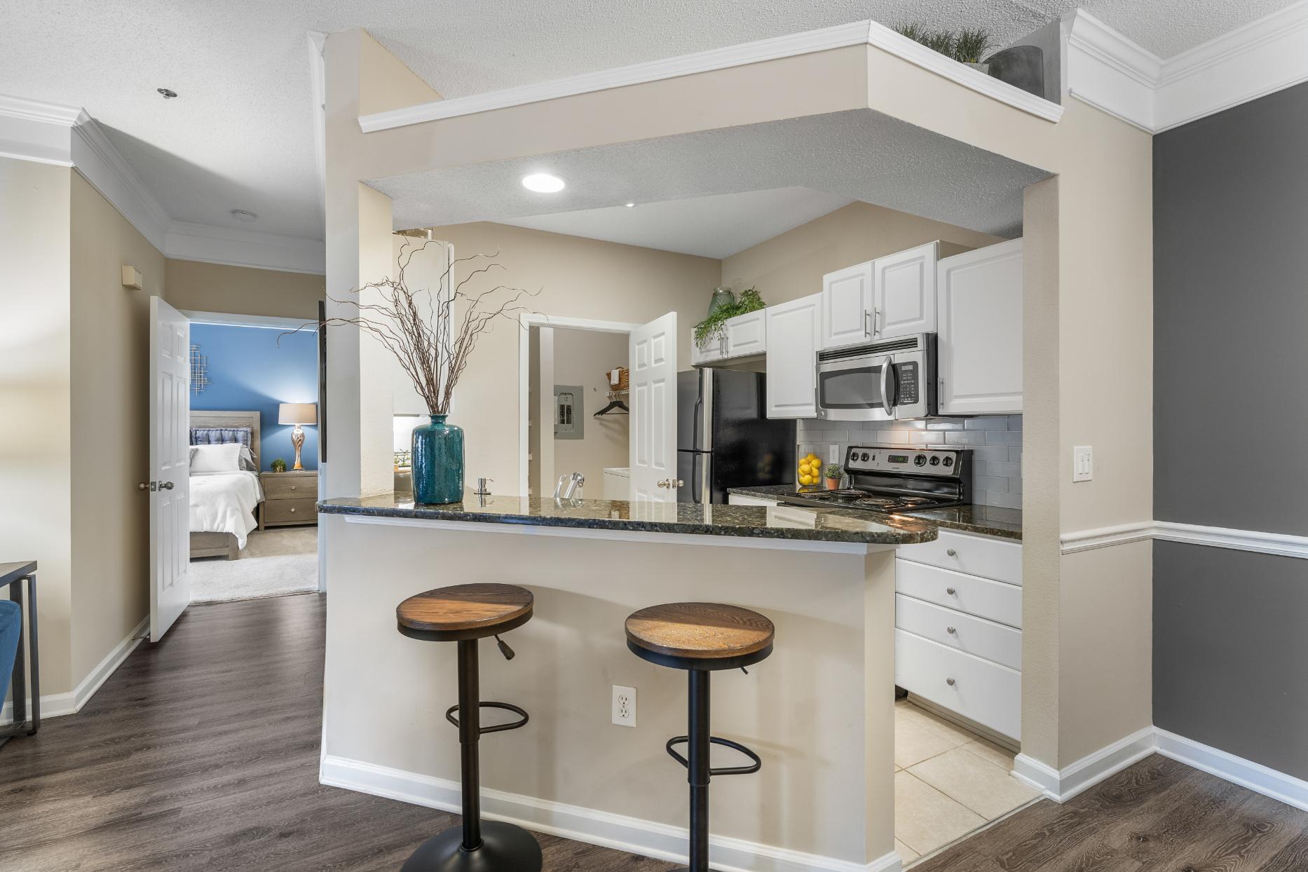 A kitchen with a bar stool in front of it.