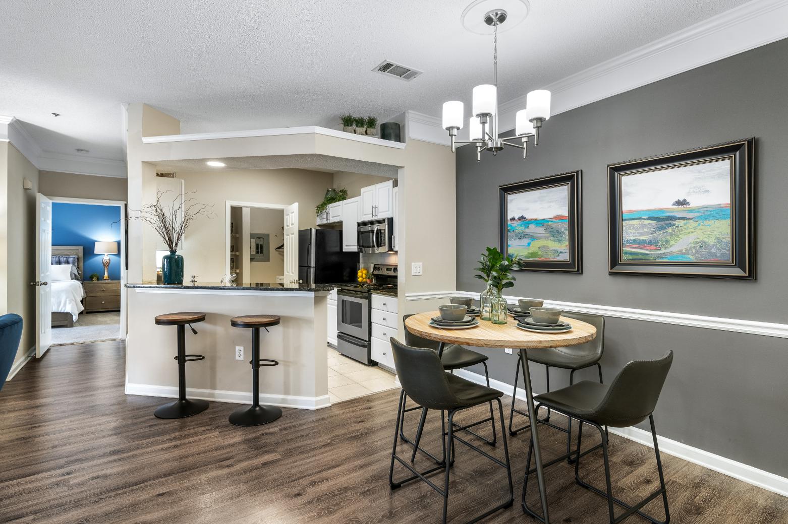 A modern kitchen with a dining table set for two.