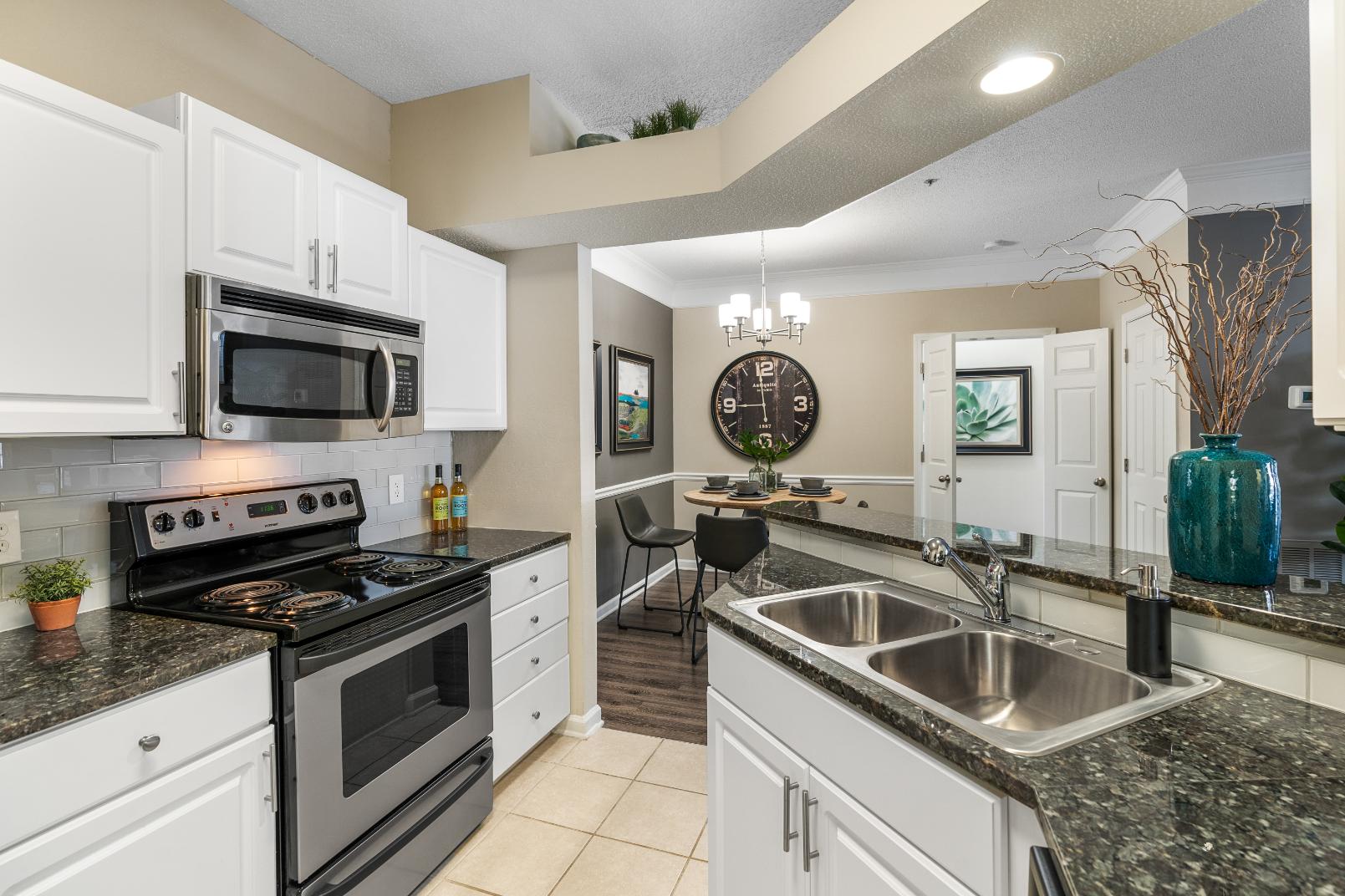 A kitchen with white cabinets and a black stove top oven.