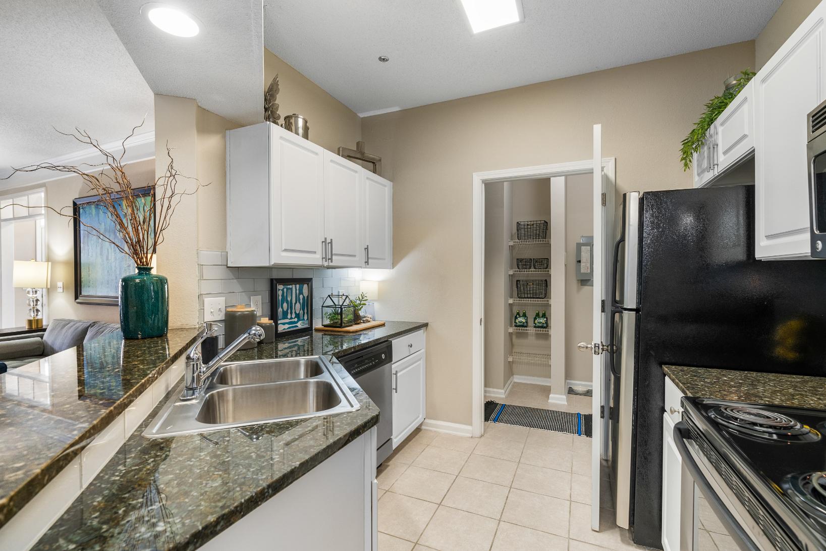 A kitchen with a black fridge and a black oven.