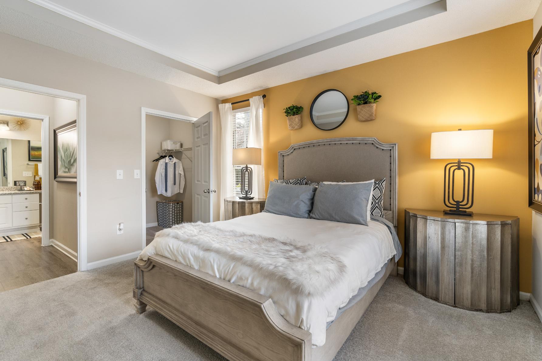 A bedroom with a large bed and a mirror on the wall.