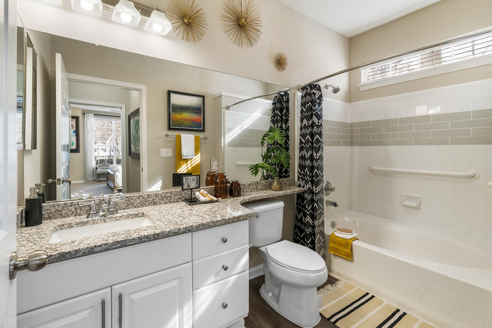 A bathroom with a white toilet, sink, and bathtub.