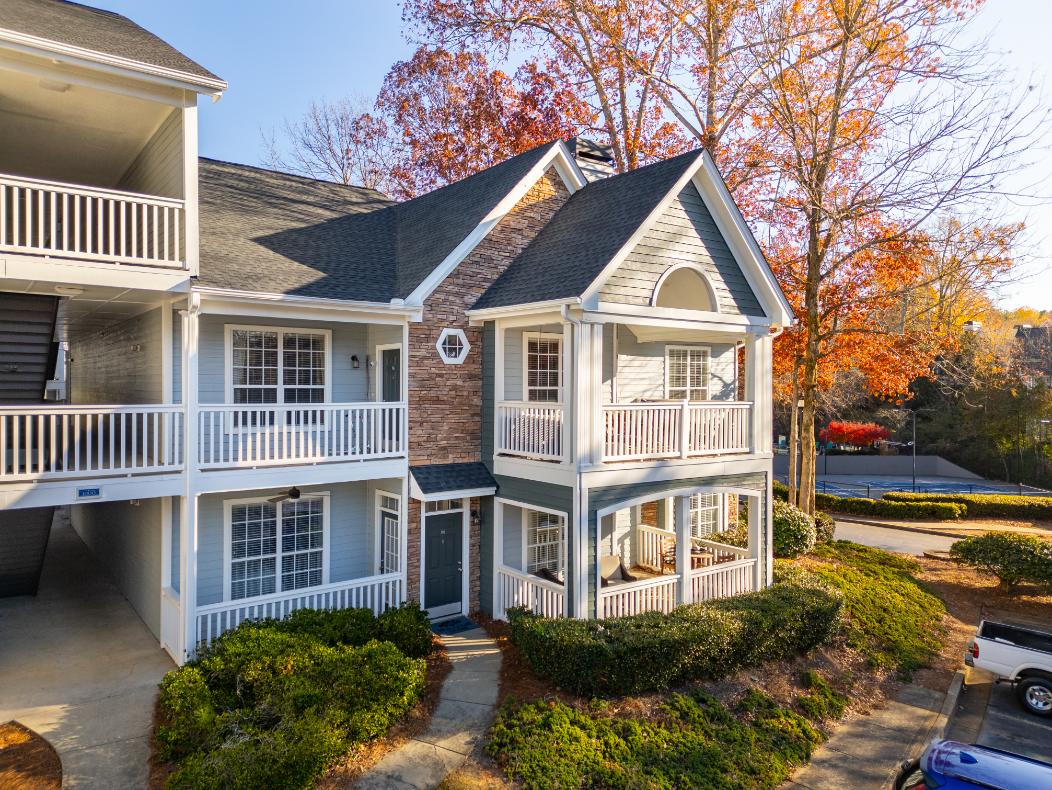 A two-story house with a balcony and a small porch.